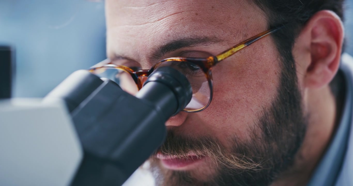 Scientist Looking Through Microscope in Laboratory