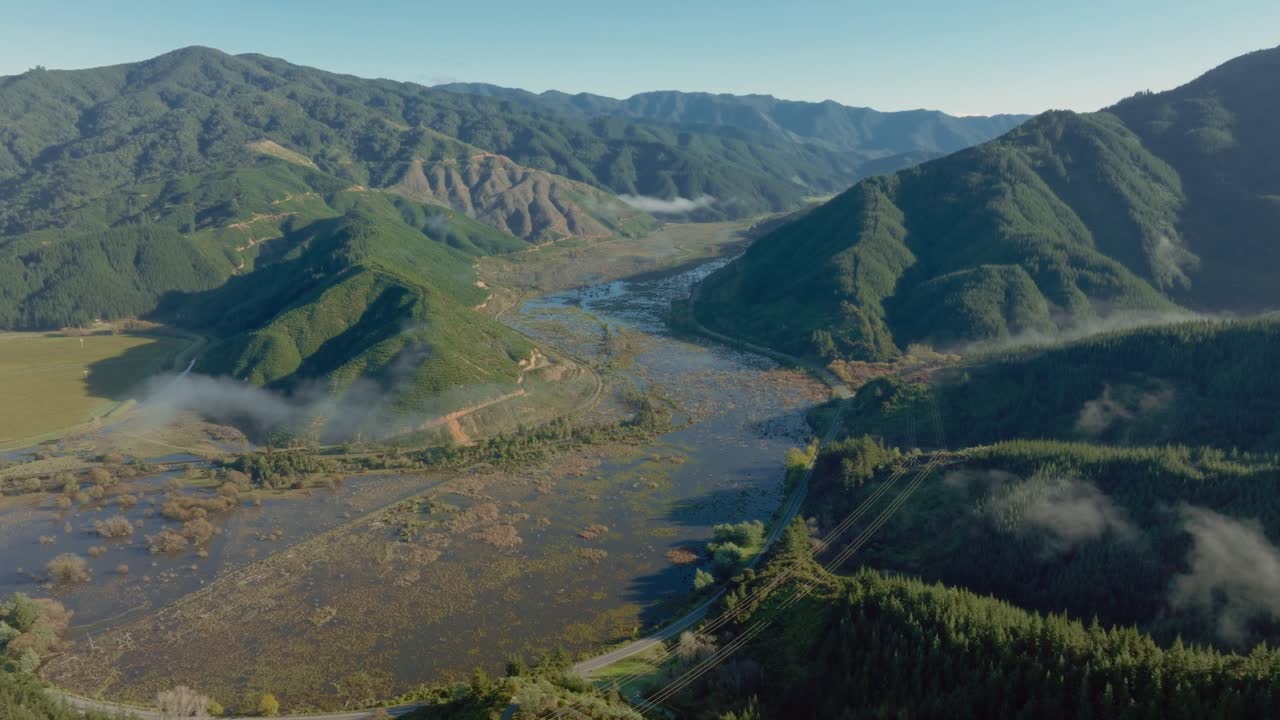 vista aérea con vistas al terreno salvaje, remoto y único del ecosistema de humedales de te paranui rodeado de un paisaje montañoso accidentado en la isla sur de nueva zelanda aotearoa