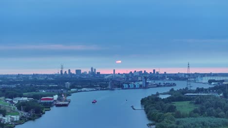 Amanece-Sobre-La-Ciudad-De-Rotterdam-Y-El-Río-Nieuwe-Maas,-Aéreo