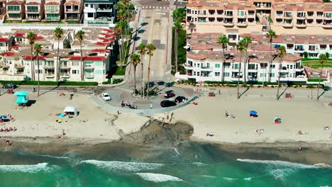 Oceanside-California-panning-left-close-up-view-of-the-beach-sand-surf-bike-path-and-hotels