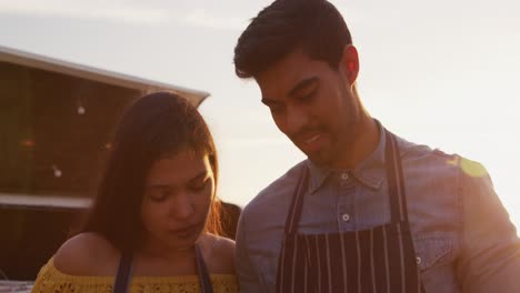 Una-Pareja-Joven-Mirando-El-Panel-Táctil-En-Un-Camión-De-Comida