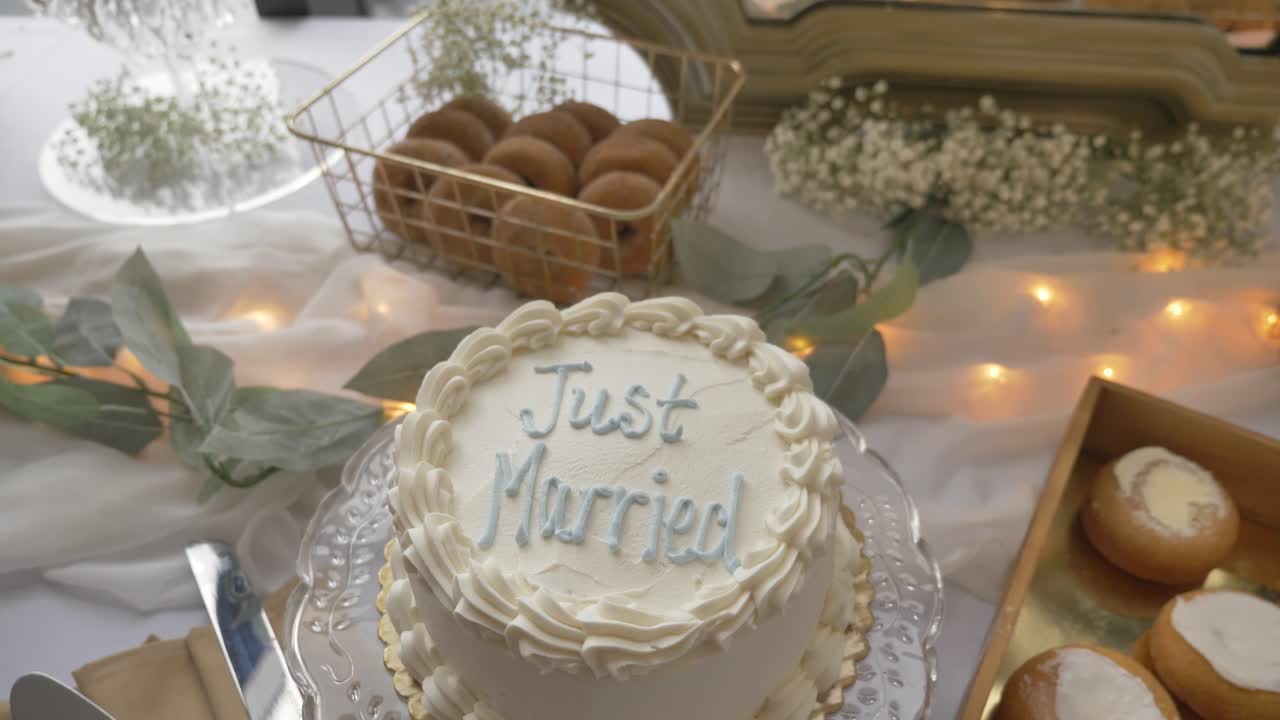 Un tavolo da dessert con torta nuziale recante la scritta Sposi