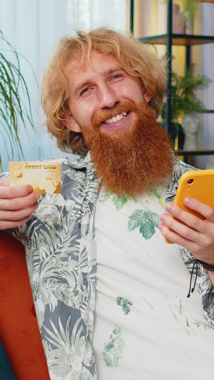 Caucasian man using credit bank card and smartphone transferring money purchases online shopping