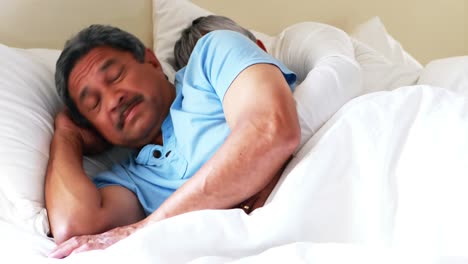 senior man getting disturbed with woman snoring on bed 4k
