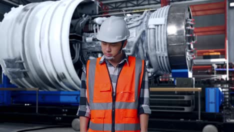 asian male engineer with safety helmet having a headache while working with airplane engine maintenance conducted, analytics checking the turbine