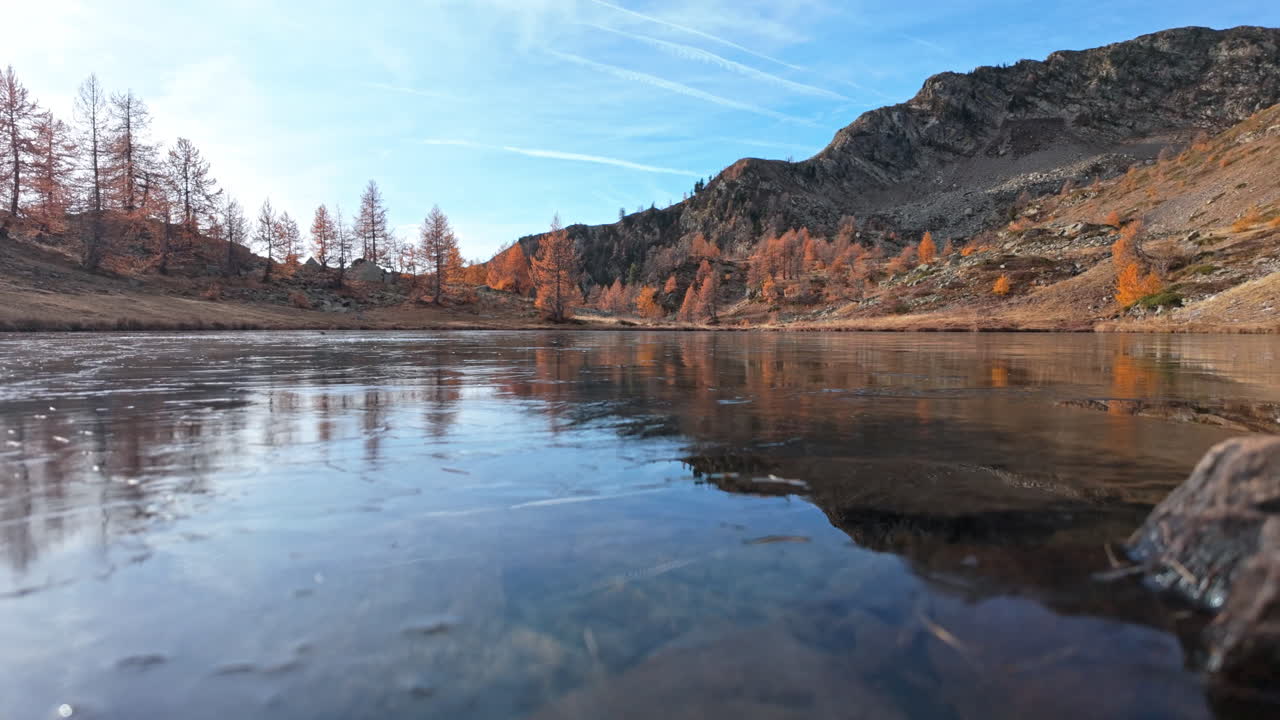 Calm mountain lake with autumn trees and clear blue sky in fall season