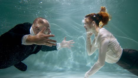anger management cinematic underwater shot of young angry businessman and woman argue shout at each other slow motion.
