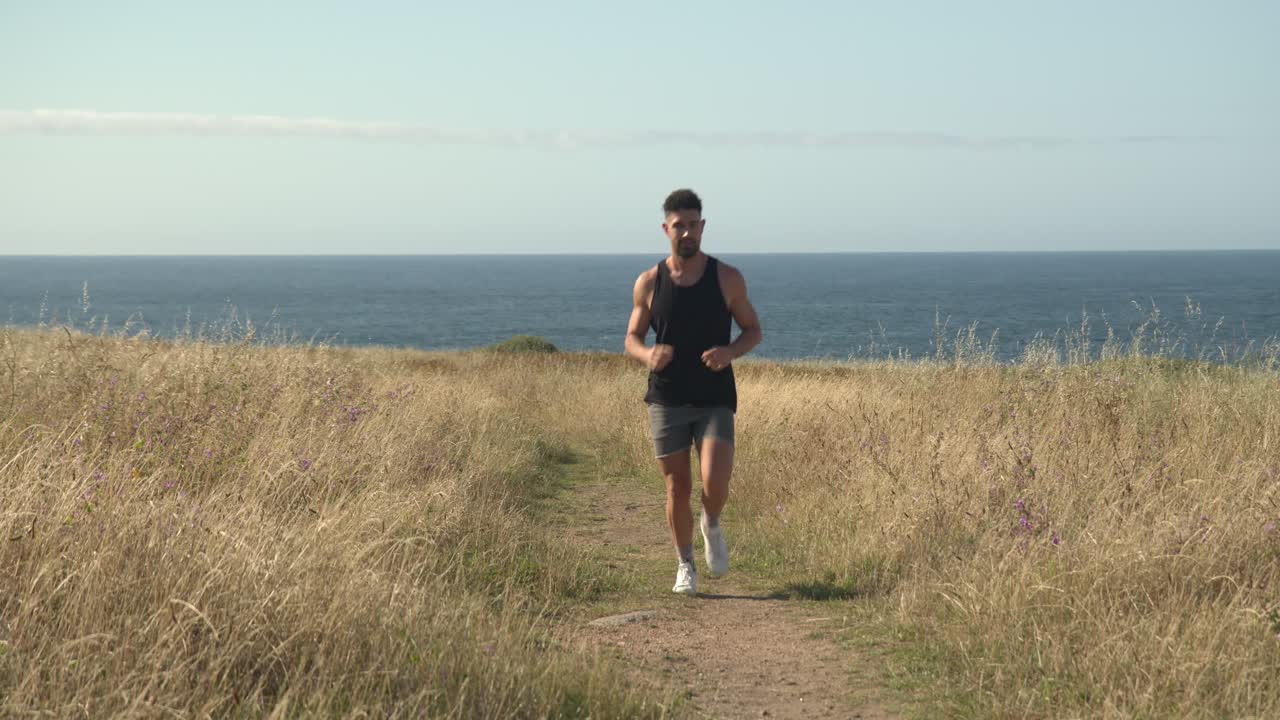 hombre corriendo por el camino a la orilla del mar