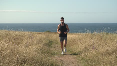 man running along path at seaside