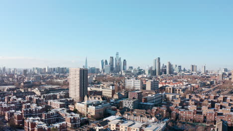 Low-wide-rising-drone-shot-of-city-of-London-skyscrapers-clear-day-after-snow
