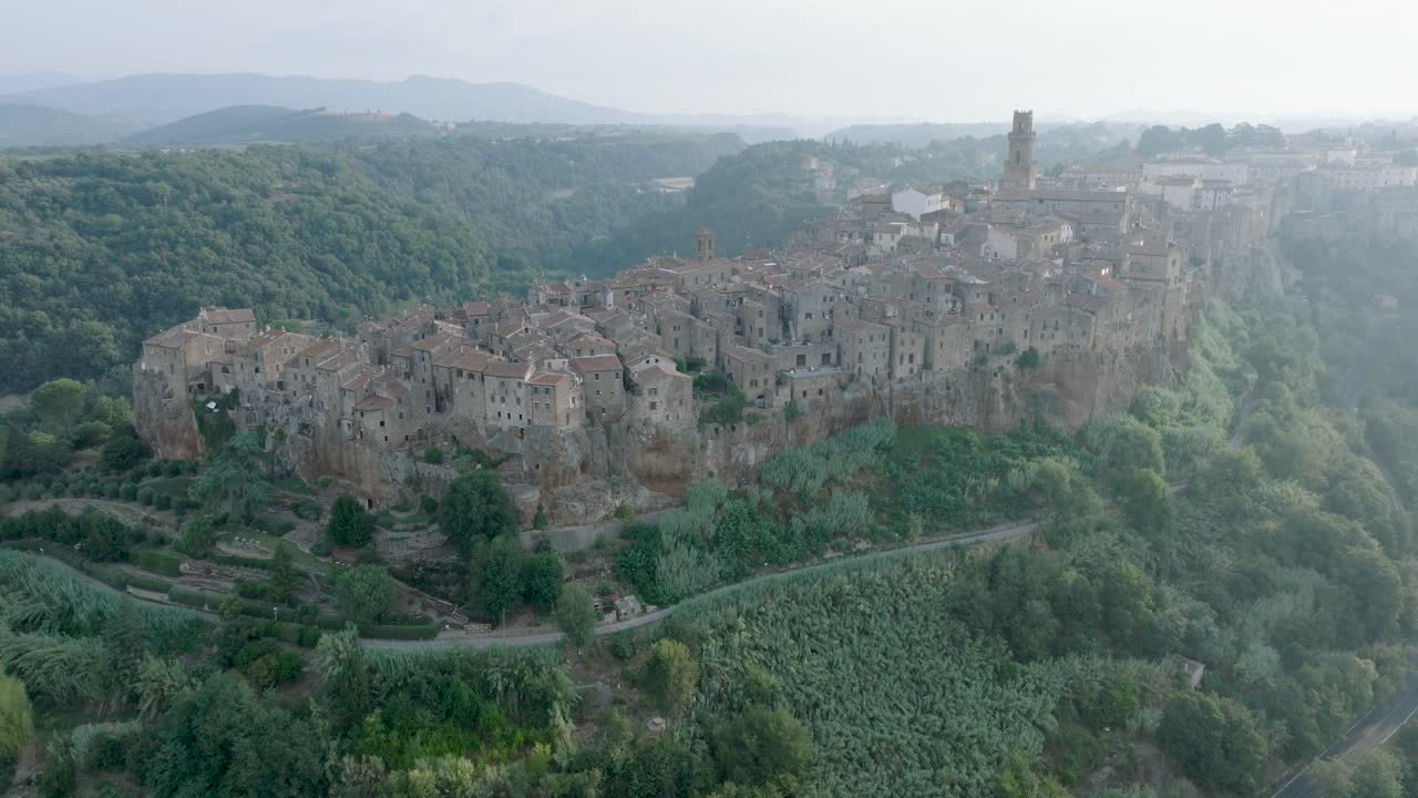 Aerial Drone view of the hilltop Medieval town of Pitigliano, Tuscany and the Valdorcia in morning light, flying over old buildings and rooftops, in 4K