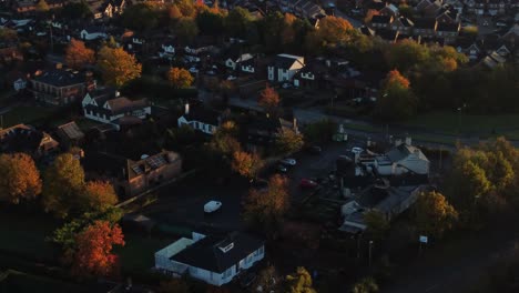 british neighbourhood housing aerial view looking down over early morning sunrise autumn coloured rooftops