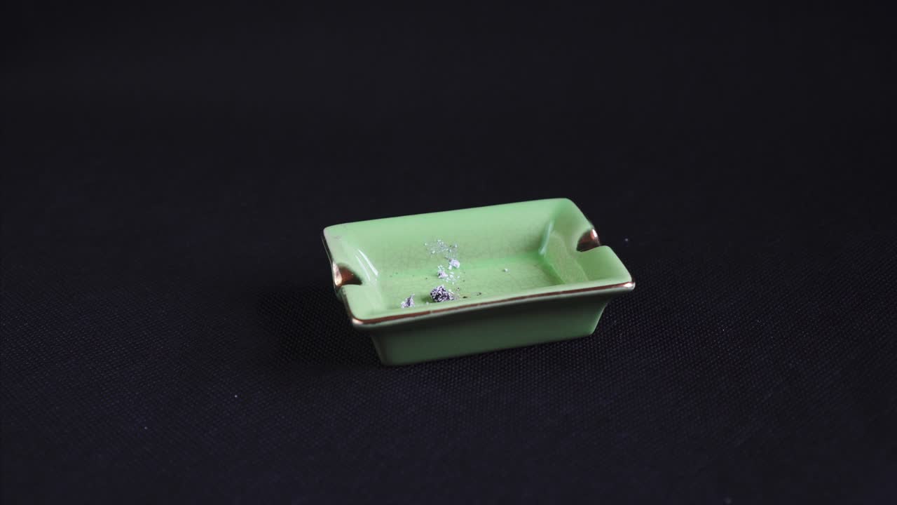 fumar y dejar un cigarrillo enrollado o un porro, marihuana legalizada en un cenicero verde