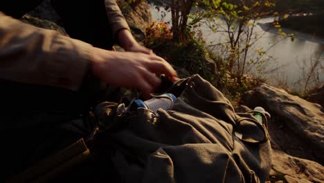 hiker removing gas bottle from his backpack to make coffee in morning, vogelberg