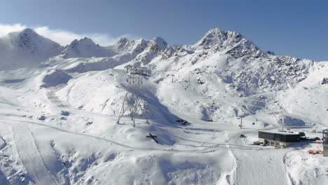 Aerial-panorama-shot-of-ski-area-in-Kauntertal-Austria-with-Christian-cross-of-people-on-the-mountainside-with-skiing-skier-during-winter-season