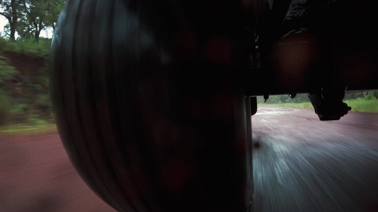 POV (point of view) footage back facing all-terrain 4x4 tyre moving at speed along a muddy dirt road in Cape York, remote Australia