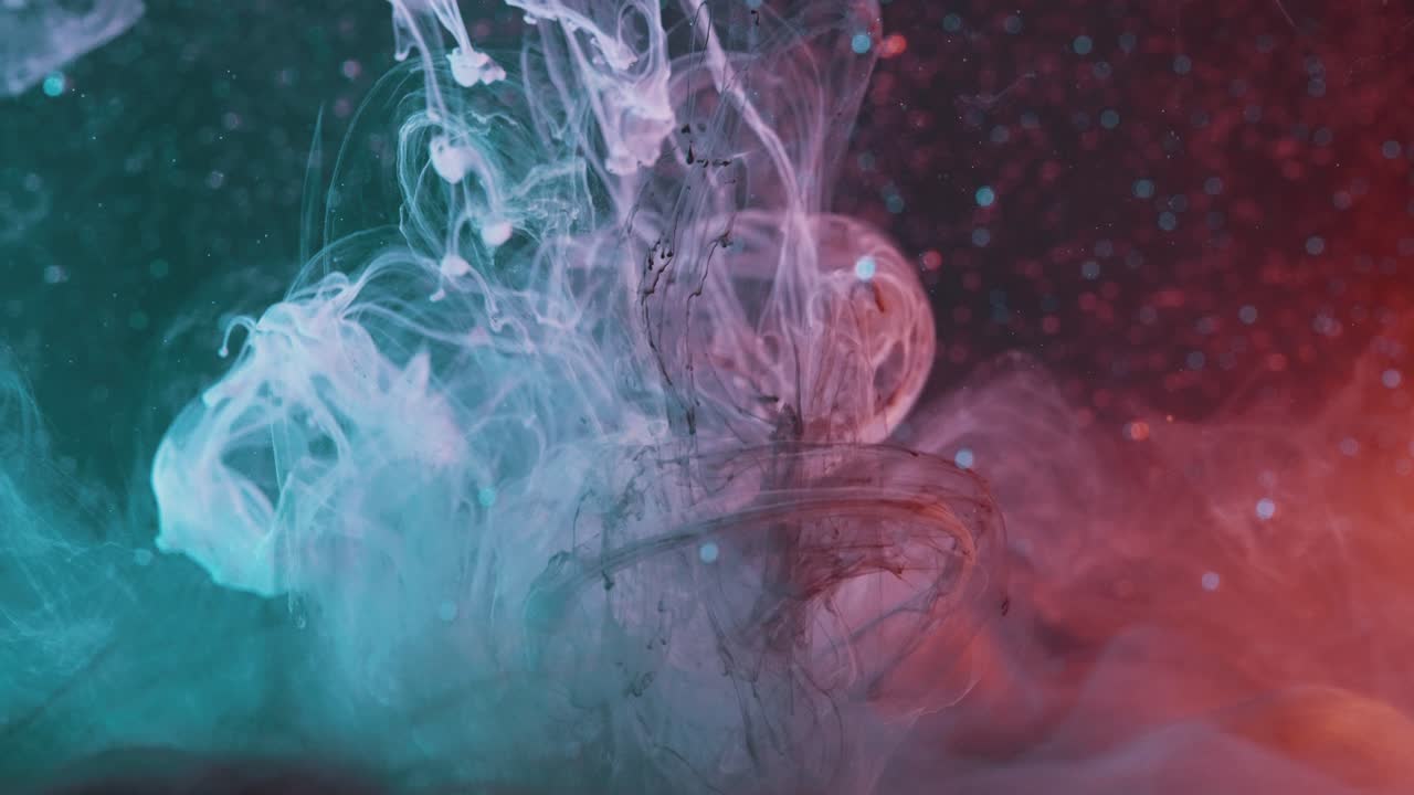 Mélange de couleurs, liquide turquoise, rouge et noir se déplaçant à l'intérieur d'un récipient d'eau
