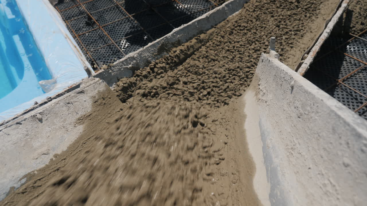 el hormigón fluye por las canaletas donde los trabajadores pavimentan 5