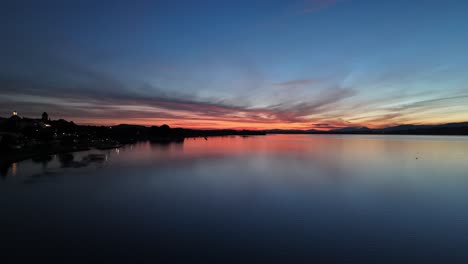 lake sunset revealshot with drone over murten switzerland.