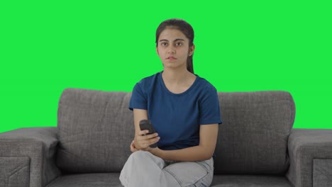 Serious-Indian-teenage-girl-watching-TV-Green-screen