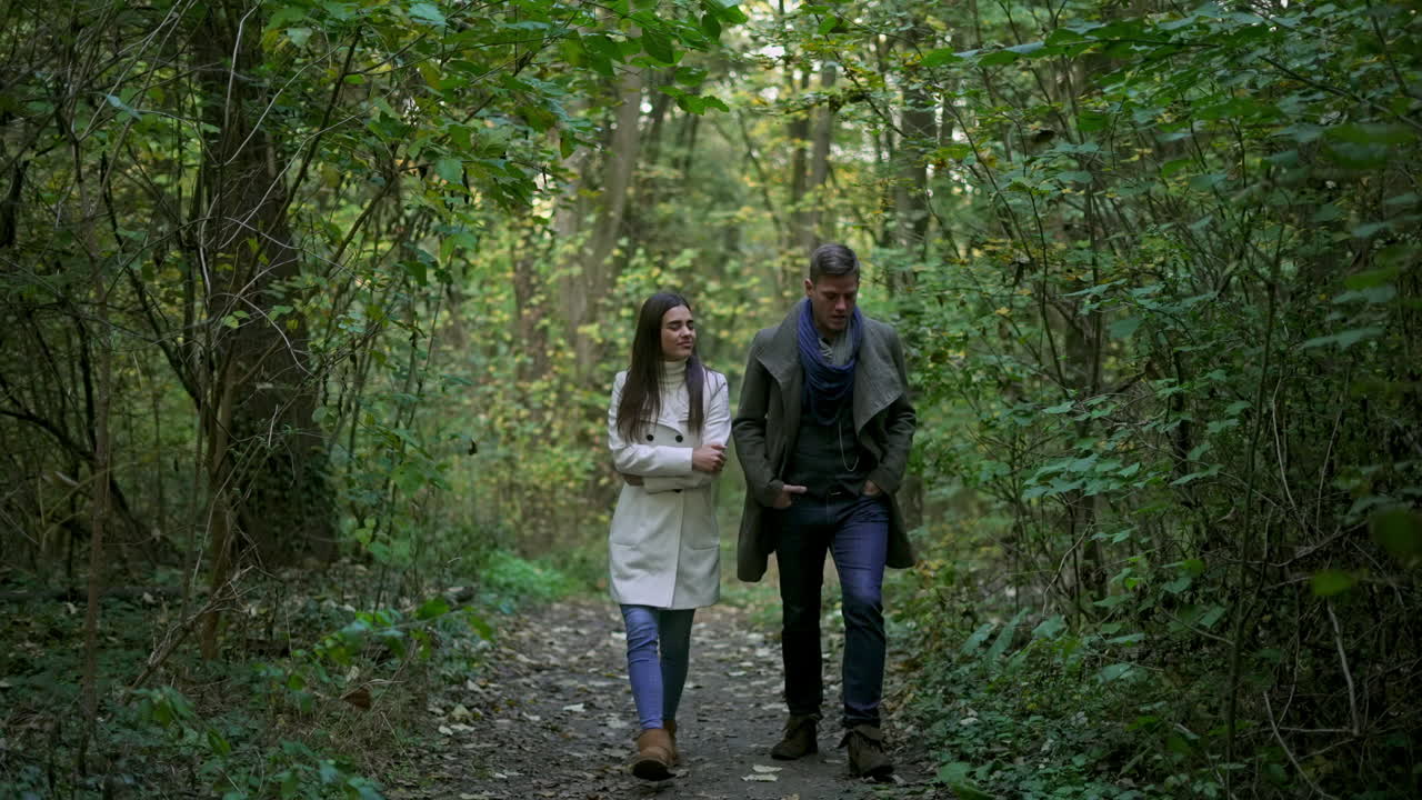 una pareja caminando por el bosque