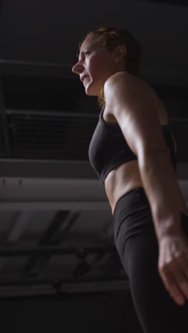 vertical video close up studio shot of mature woman wearing gym fitness clothing doing cardio exercise