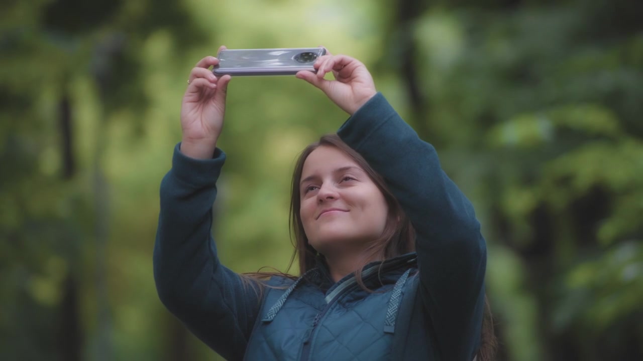 Donna che scatta foto nella foresta