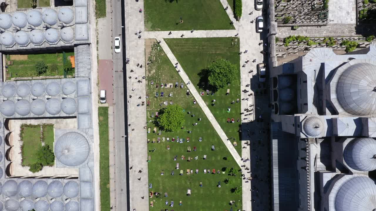 personas que rezan a distancia social en el jardín de la mezquita durante el período de coronavirus