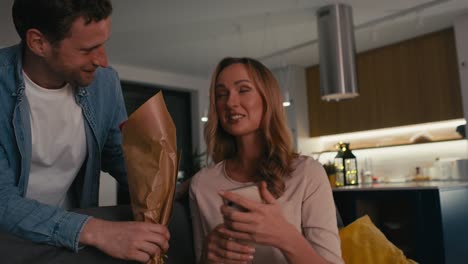 una pareja caucásica intercambiando regalos para el día de san valentín.
