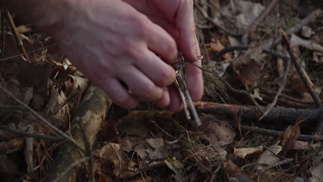 llaves en llavero perdidas en el bosque finalmente encontradas, manos cerca de vista de ángulo alto, día de suerte o concepto de evidencia de crimen