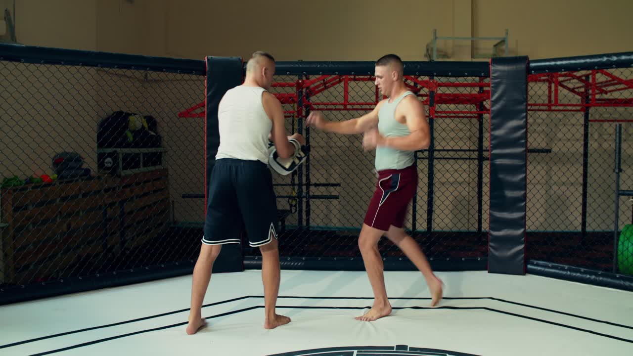 MMA-kæmpere træner i et bur
