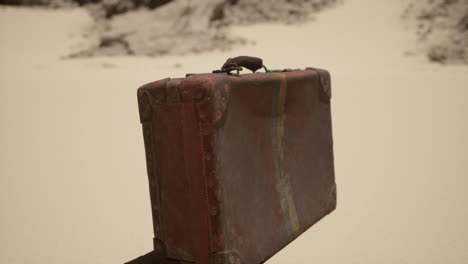 vintage leather suitcase abandoned in the desert