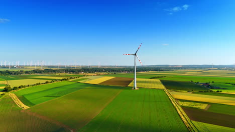 wind turbine stands tall in green fields. a wind turbine rotates majestically above vibrant green fields under a clear blue sky in a rural landscape