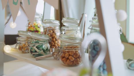 Schließen-Sie-Oben-Auf-Dem-Schokoriegelstand-Bei-Der-Hochzeit-Mit-Bunten-Süßigkeiten-In-Den-Gläsern