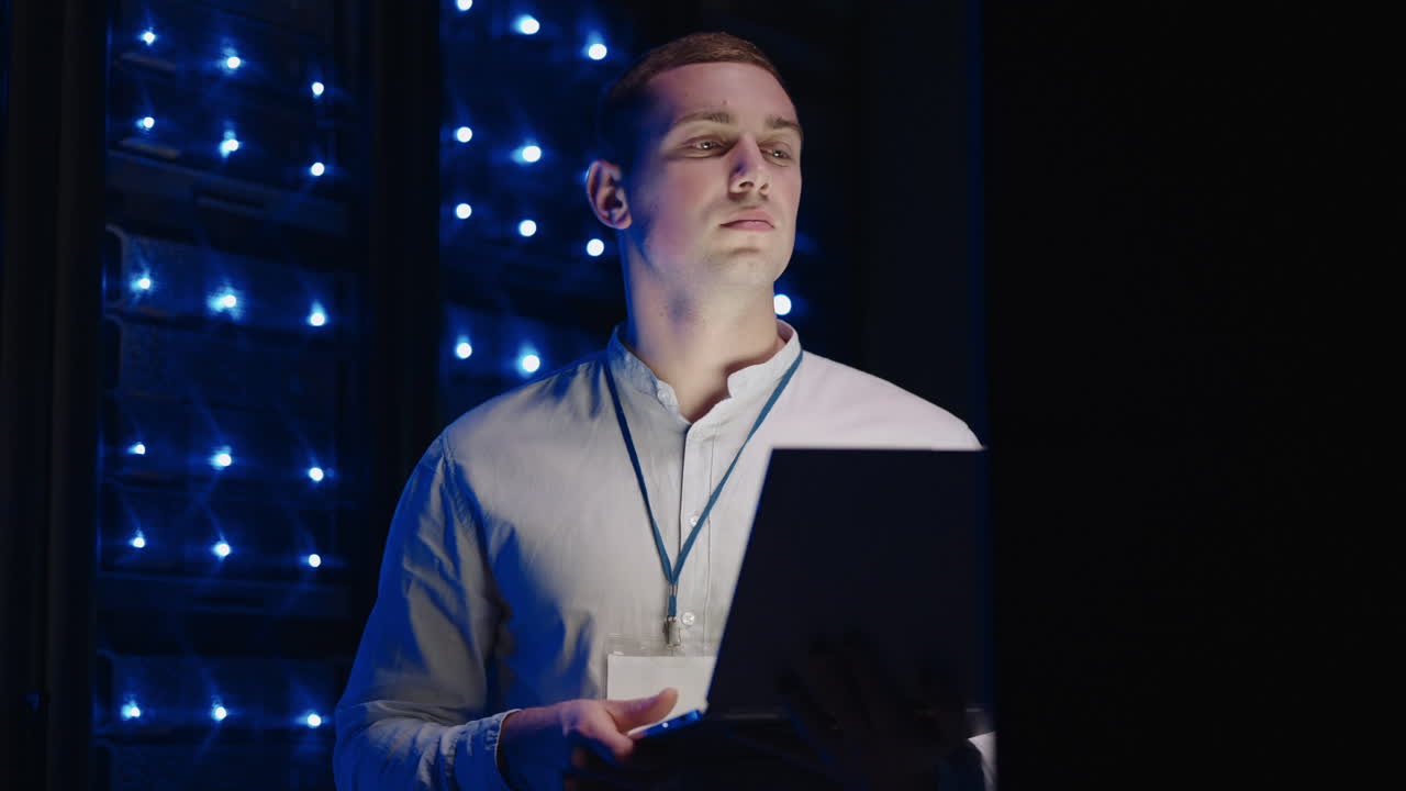 concepto de digitalización de la información: es especialista frente a los racks de servidores con portátil activa el centro de datos con un gesto táctil. trabajando en un portátil de pie frente al gabinete de rack de servidor abierto