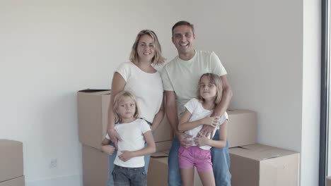 Happy-family-couple-with-children-waving-hello