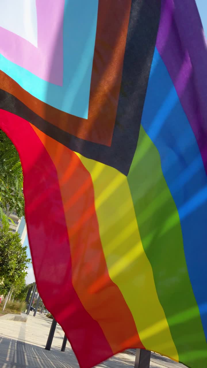 LGBTQ Pride Flag Flying in City Landscape