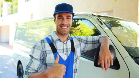 Smiling-handyman-leaning-against-his-van