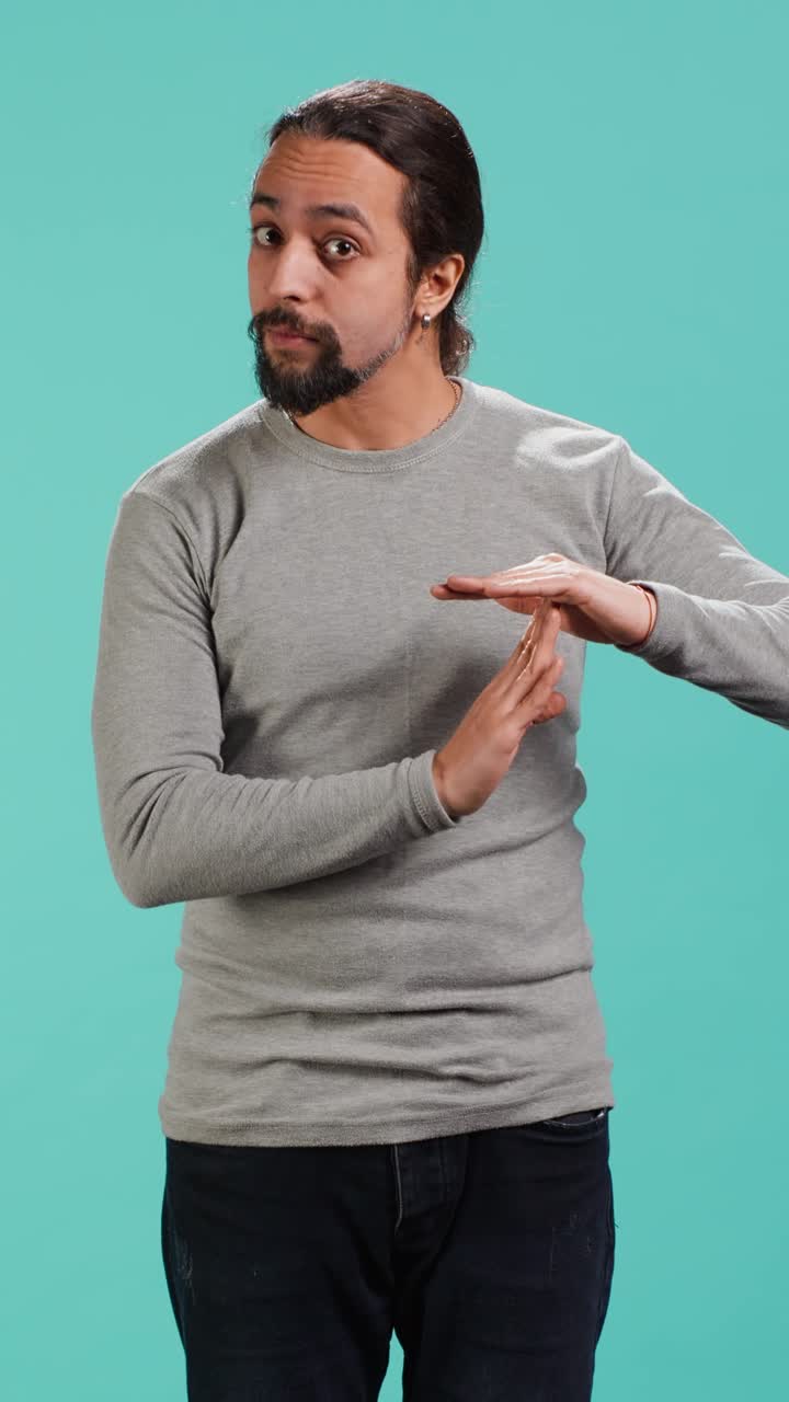 Vertical video Portrait of assertive man asking for timeout, doing hand gestures