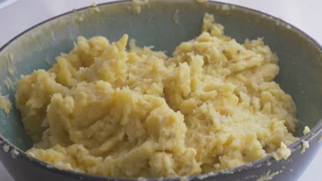 adding fried garlic and hot oil to the mashed banana plantain puree and salt