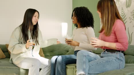 Multi-ethnic women talking and drinking at home