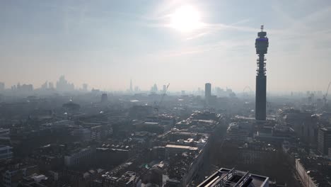 drone push in london skyline and bt tower silhouetted against low rising sun