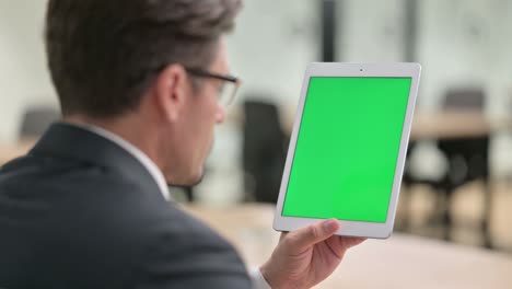 vista trasera de un hombre de negocios usando una tableta con pantalla cromada
