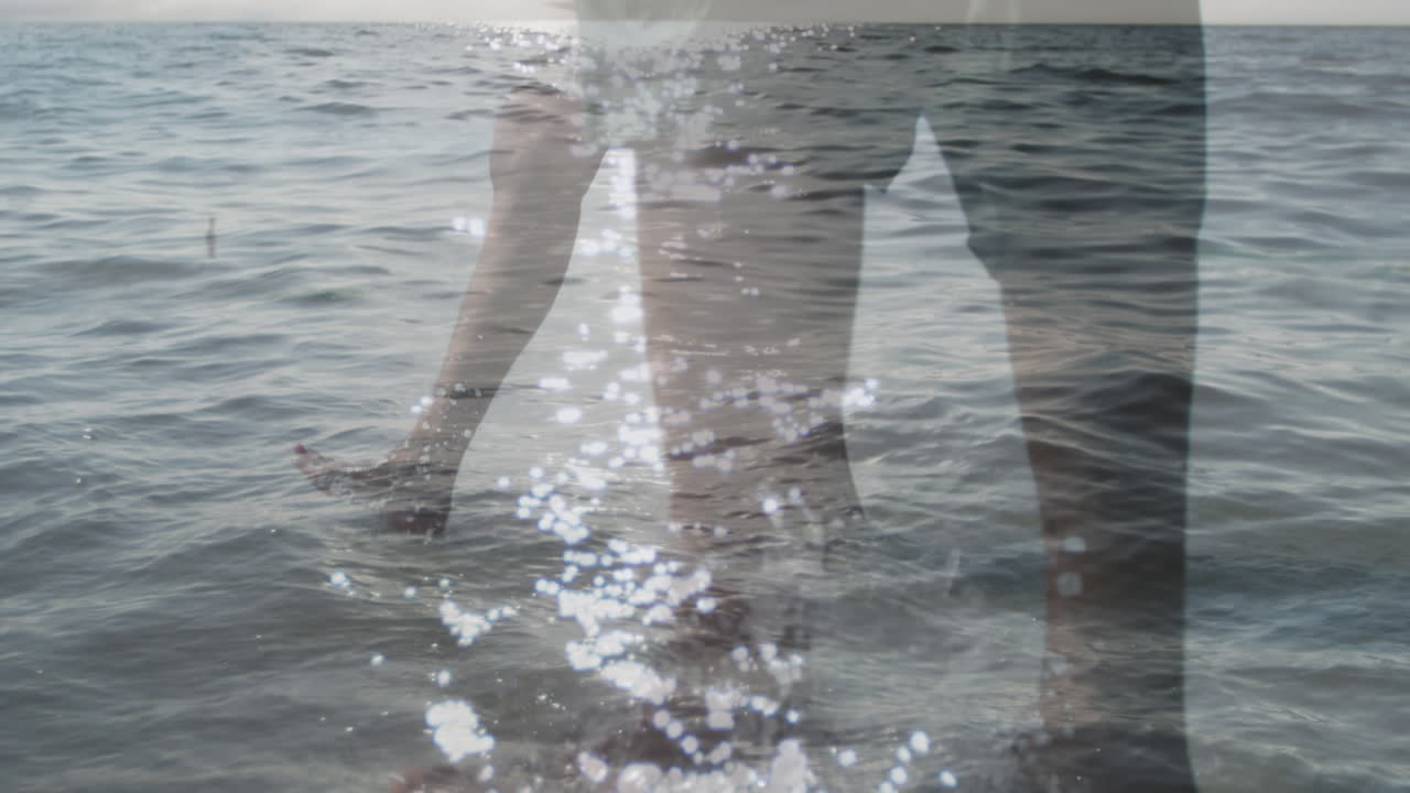 해변에서 함께  ⁇ 고 있는 백인 부부의 낮은 부분에 대한 바다 파도의 복합 비디오