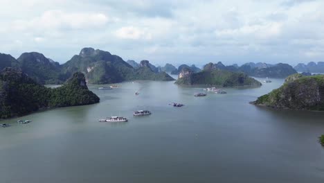 semi orbit aerial showing tourist boats anchored in cat ba bay, surrounded by limestone islets