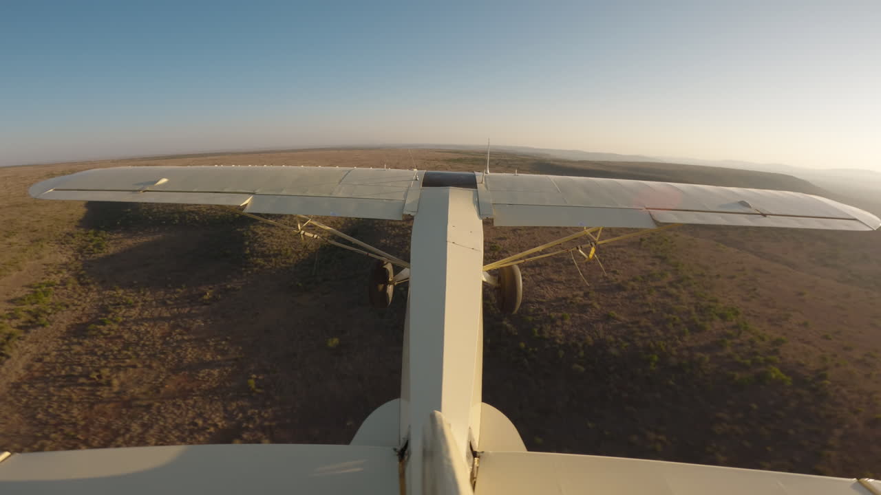 Aereo da bushcraft in volo sopra un fiume e scarpate nella savana
