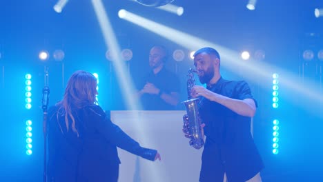 musical band group of vocalist, saxophonist, dj playing song, performing on musician concert stage