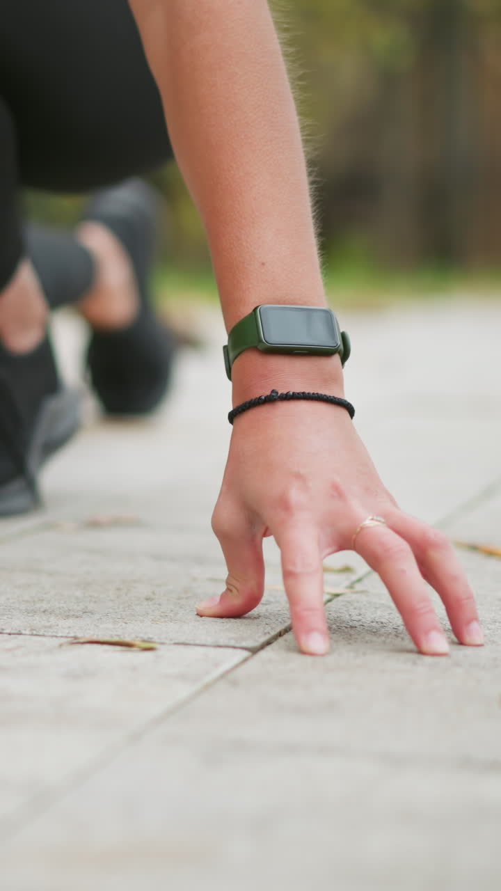 Partial view of girls hands placed on ground, preparing for sprint, focused on setting position, athletic stance, outdoor exercise, fitness training, ready to run, motion blur, dynamic movement