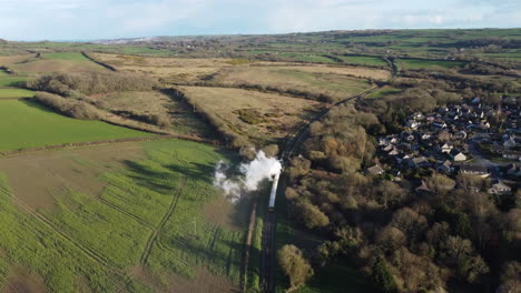 Steam-Train-travelling-through-English-countryside---Drone-wide-shot-showing-landscape