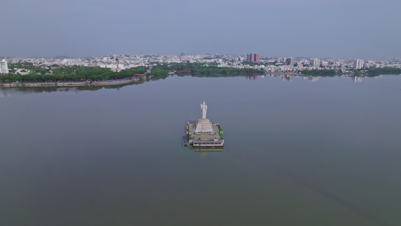 Hussain Sagar Lake with buddha statue in background crowded building at tank bund, Khairtabad, Hyderabad, Telangana, india. day time, push in, drone shot, 4k.